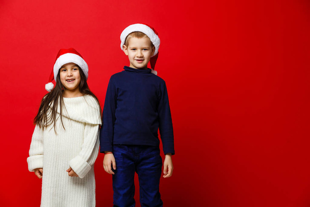 Girl and boy posing against red  - Foto, afbeelding