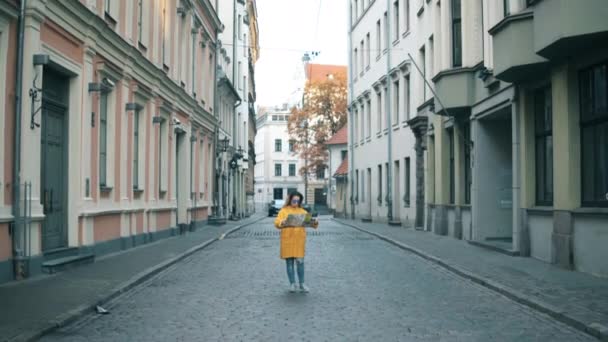 Female tourist looks at a map while standing on a street. - Záběry, video