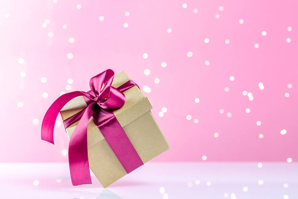 New years background. Christmas gift box with ribbon on pink. Banner mock up for display of product or design content. Xmas present - Φωτογραφία, εικόνα