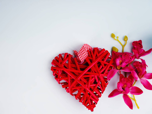 Achtergrond met bloemen en decoratieve rode hart in lichtstraal - Foto, afbeelding