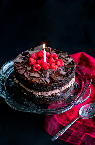 Encender la vela encima de un delicioso pastel de chocolate
 - Foto, Imagen