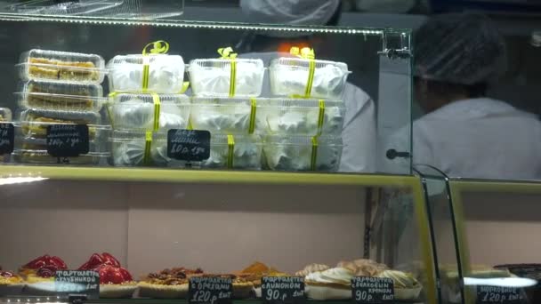 Brownies in glazen bakkerij vitrine. Onherkenbaar personeel in witte schorten en hoeden - Video
