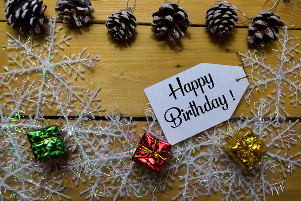 Happy Birthday write on label with wooden backgroud. Frame of Christmas Decoration. - 写真・画像