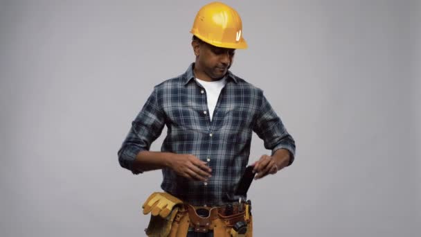 indian builder in helmet calling on smartphone - Video, Çekim
