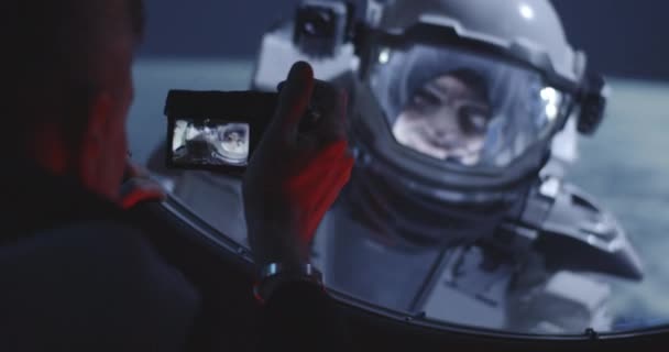 Astronauta filmando companheiro de equipe de caminhada espacial
 - Filmagem, Vídeo