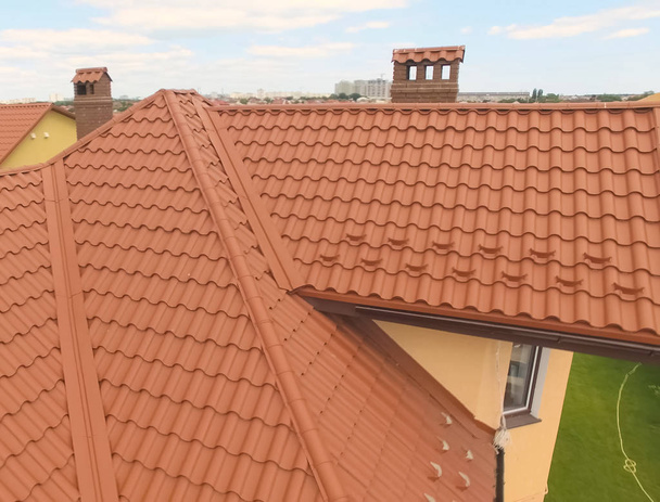 Casa con un nuevo techo de metal naranja. Vista desde arriba. Cor.
 - Foto, Imagen