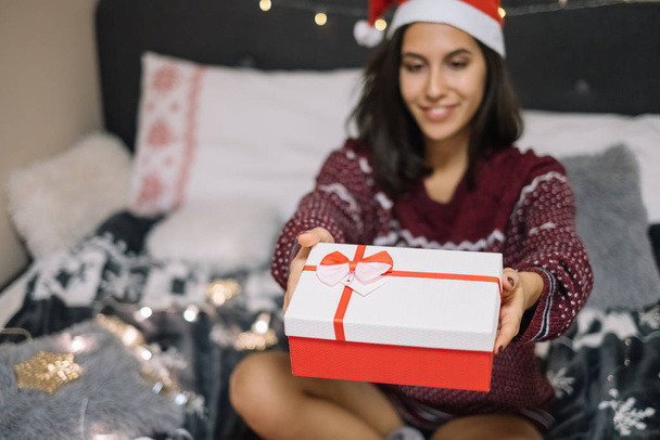 Woman giving Christmas gift box to camera - Foto, Imagem