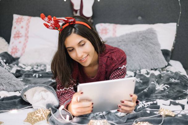Woman with red headband looking at her tablet - Photo, Image