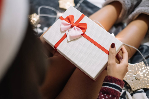 Close-up of naked womans legs with gift box - Фото, изображение