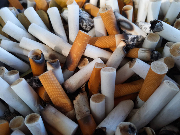 Niedopałki i popioły papierosów, popielniczka pełna niedopałków papierosów - Zdjęcie, obraz