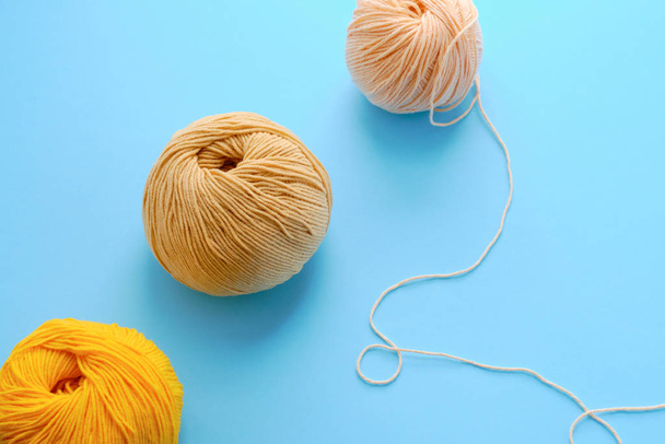 Mock-up made with bright color yarn clews on the blue background. Concept of amigurumi toy making, handicraft, knitting, hobbie. Can be used for posters - 写真・画像