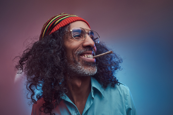Studio portrait of African Rastafarian male smoking cigarettes - Fotoğraf, Görsel