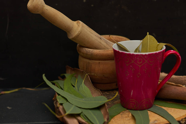 eucalyptus medicine tea over wood in dark background - Photo, Image