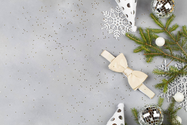 Fond de Noël avec nœud papillon blanc et décorations : boules, branches d'arbre, casquettes. mode pour hommes de Noël
. - Photo, image