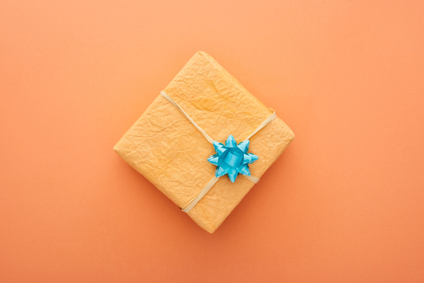 vue du dessus de la boîte cadeau avec arc bleu isolé sur orange
  - Photo, image