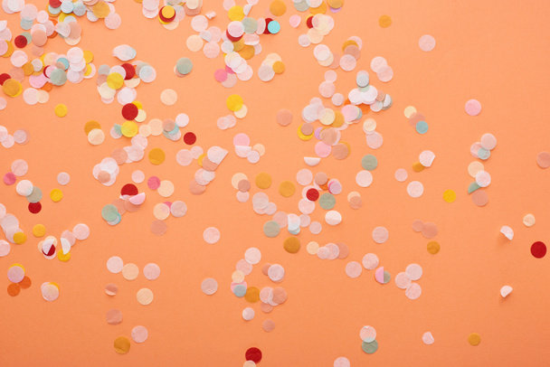 decorative and colorful confetti on orange background  - Photo, Image