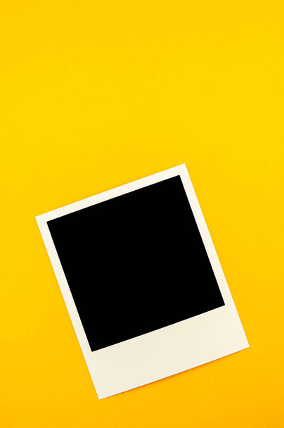 photo with the image of a black square lies on a yellow backgrou - Photo, Image