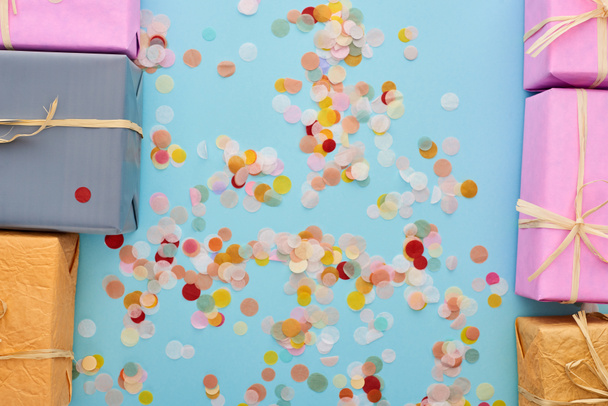 vista superior de presentes embrulhados perto de confete em azul
  - Foto, Imagem