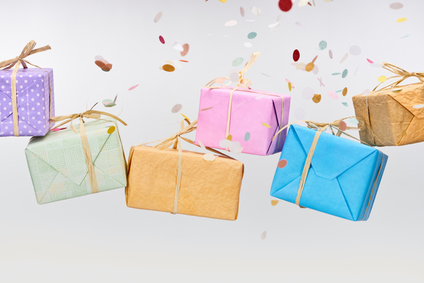 falling confetti near colorful and wrapped presents on white - Foto, immagini
