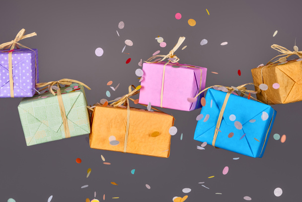 falling confetti near colorful gifts on grey  - Photo, Image