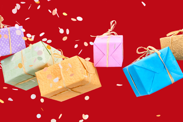 confettis tombant près de boîtes-cadeaux colorées sur rouge
 - Photo, image