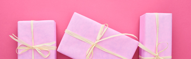 panoramic shot of gift boxes with bows on pink  - Фото, изображение