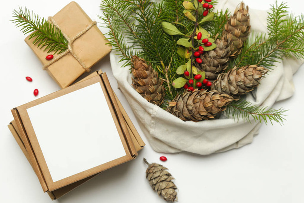 Zero Waste Verpackung Geschenke Konzept. Natürliche Weihnachtsdekoration, Tannenzapfen und Tannenzweige in Baumwolltasche. - Foto, Bild