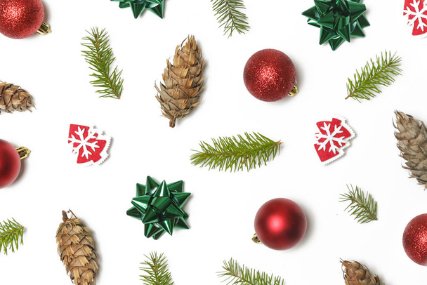 Slavnostní zimní zázemí. Červené vánoční ozdoby, zelené luky a jedlové větve izolované na bílém pozadí. Vánoce, zimní dovolená, novoroční koncept. - Fotografie, Obrázek