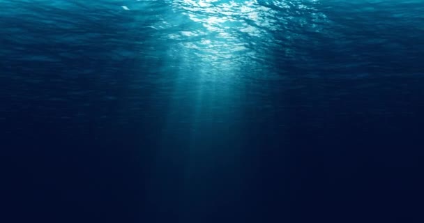 naadloze lus van diepblauwe oceaan golven van onderwater achtergrond, licht stralen schijnt - Video