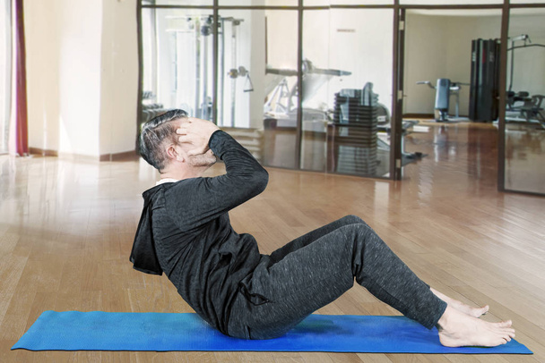 Man doing sit-up exercise at gym - Fotó, kép