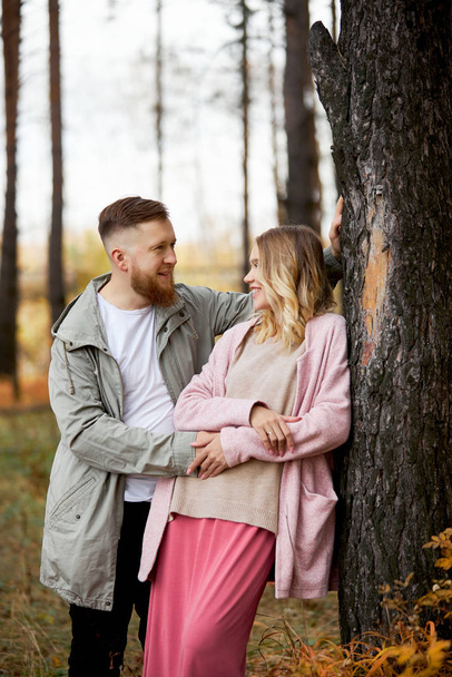 Couple in love walks through autumn forest. Hugs and kisses of m - Фото, зображення