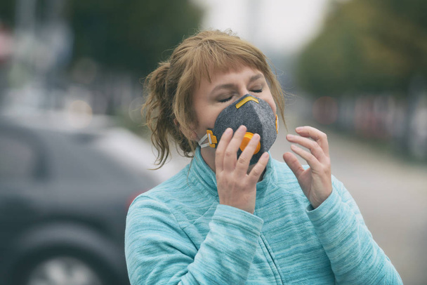 Woman wearing a real anti-pollution, anti-smog and viruses face  - Foto, Bild