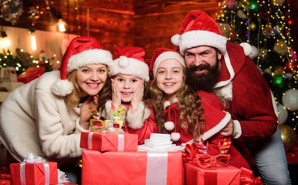 New 2020 Year is coming. Happy family celebrate new year. merry christmas. Father and mother love kids. small children and parents in santa hat. lot of xmas present boxes. Portrait loving family - Photo, image