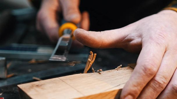 Carpintaria na oficina - um marceneiro cortando o recesso no bloco de madeira com um cinzel
 - Foto, Imagem