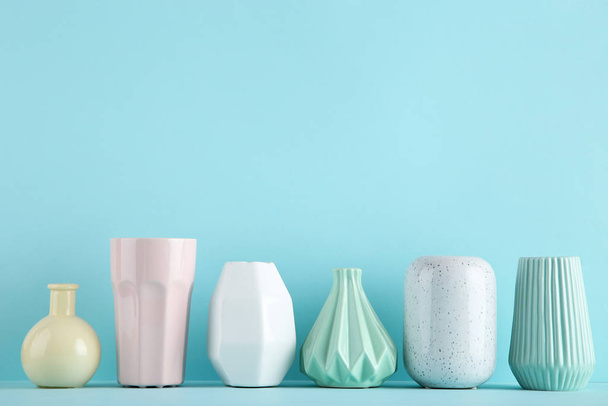 Different ceramic vases on blue background - Zdjęcie, obraz