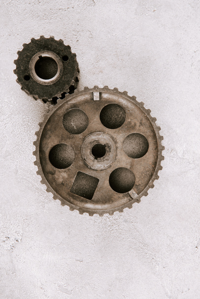 top view of aged metal round gears on grey background - Foto, Imagen