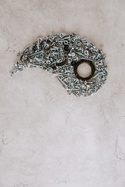 top view of aged metal screws arranged in part of taijitu symbol on grey background - Photo, Image