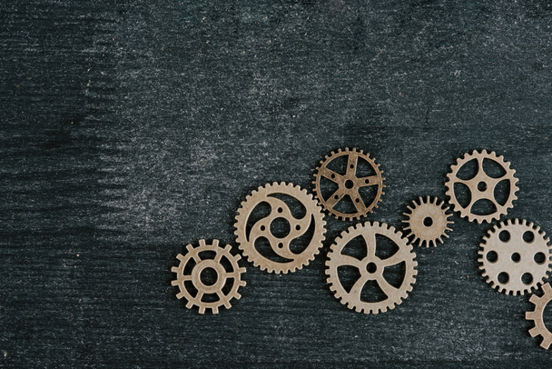 top view of retro metal gears on dark wooden background with copy space - Foto, imagen