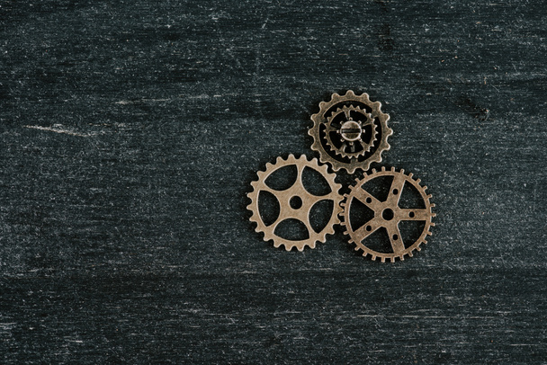 top view of vintage metal gears on dark wooden background with copy space - 写真・画像