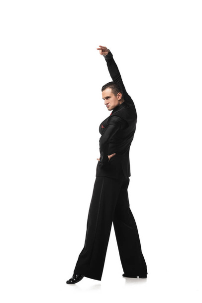 expresiva bailarina en elegante traje negro realizando tango con mano sobre cadera sobre fondo blanco
 - Foto, imagen