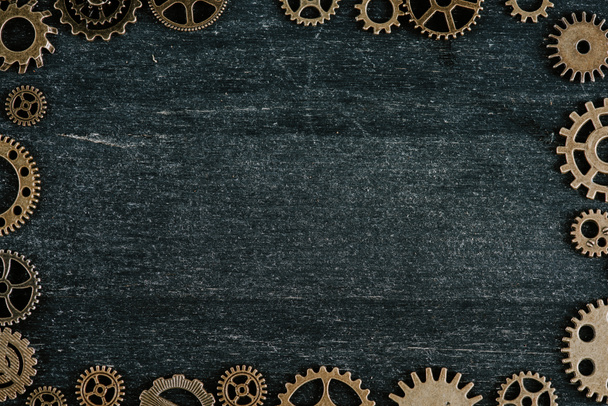 рамка из винтажного металла шестерни на темном деревянном фоне с копировальным пространством
 - Фото, изображение