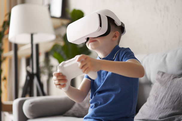 Small boy in virtual reality glasses holds game console in his hands - Foto, Imagem