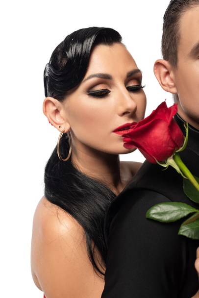 oříznutý pohled na tanečnici držící červenou růži poblíž atraktivního partnera izolovaného na bílém - Fotografie, Obrázek