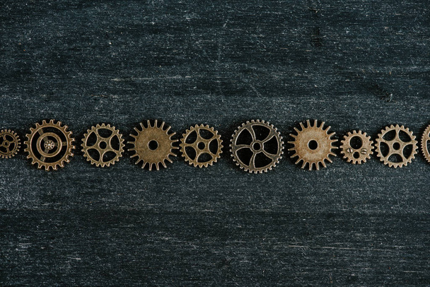 flat lay with vintage metal gears on dark wooden background - Foto, immagini