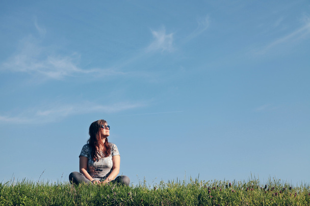 Chica sentada en una hierba
 - Foto, imagen