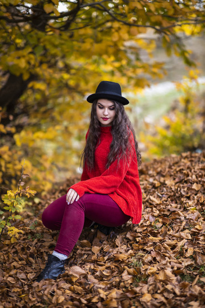 Portrait of a beautiful hispanic young woman in an autumnal fore - Фото, изображение