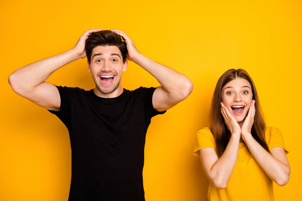 Photo of cheerful positive cute charming pretty couple rejoicing about seeing nice new information wearing black brunet t-shirt isolated over bright shiny color background - Фото, зображення