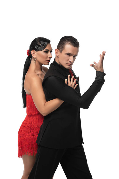handsome, elegant dancer looking at camera while performing tango with beautiful partner isolated on white - Photo, Image