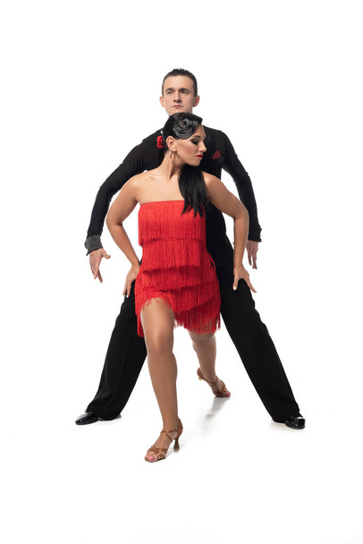 страстная, элегантная пара танцоров, исполняющих танго на белом фоне
 - Фото, изображение