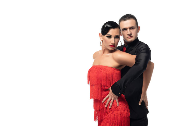 two elegant, sensual dancers looking at camera while performing tango isolated on white - Photo, Image